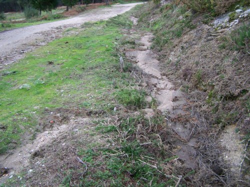 O rego que canaliza a auga, atascado de terra e area.